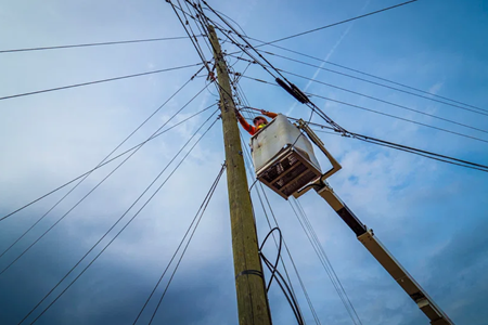 Utility pole worker suspended in bucket truck