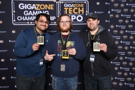 Three winners holding up their trophies from the Gigazone Gaming Championships