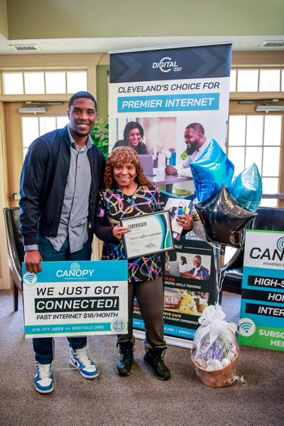 DigitalC CEO Joshua Edmonds celebrates extending internet service Glen Haven connectivity with an African American woman resident