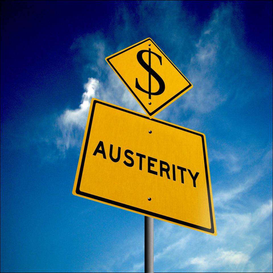 A yellow road sign reads "Austerity" 