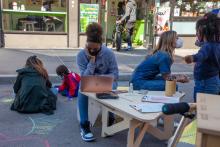 A young African American girl uses her laptop outdoors thanks to community WiFi